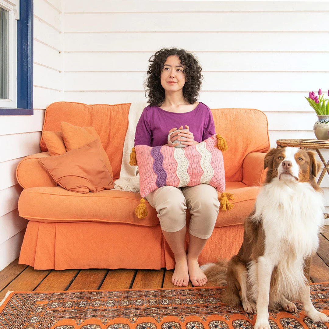 Drifting Away Pillow is a contemporary crochet pillow pattern featuring fun squiggle details and four chunky tassels.